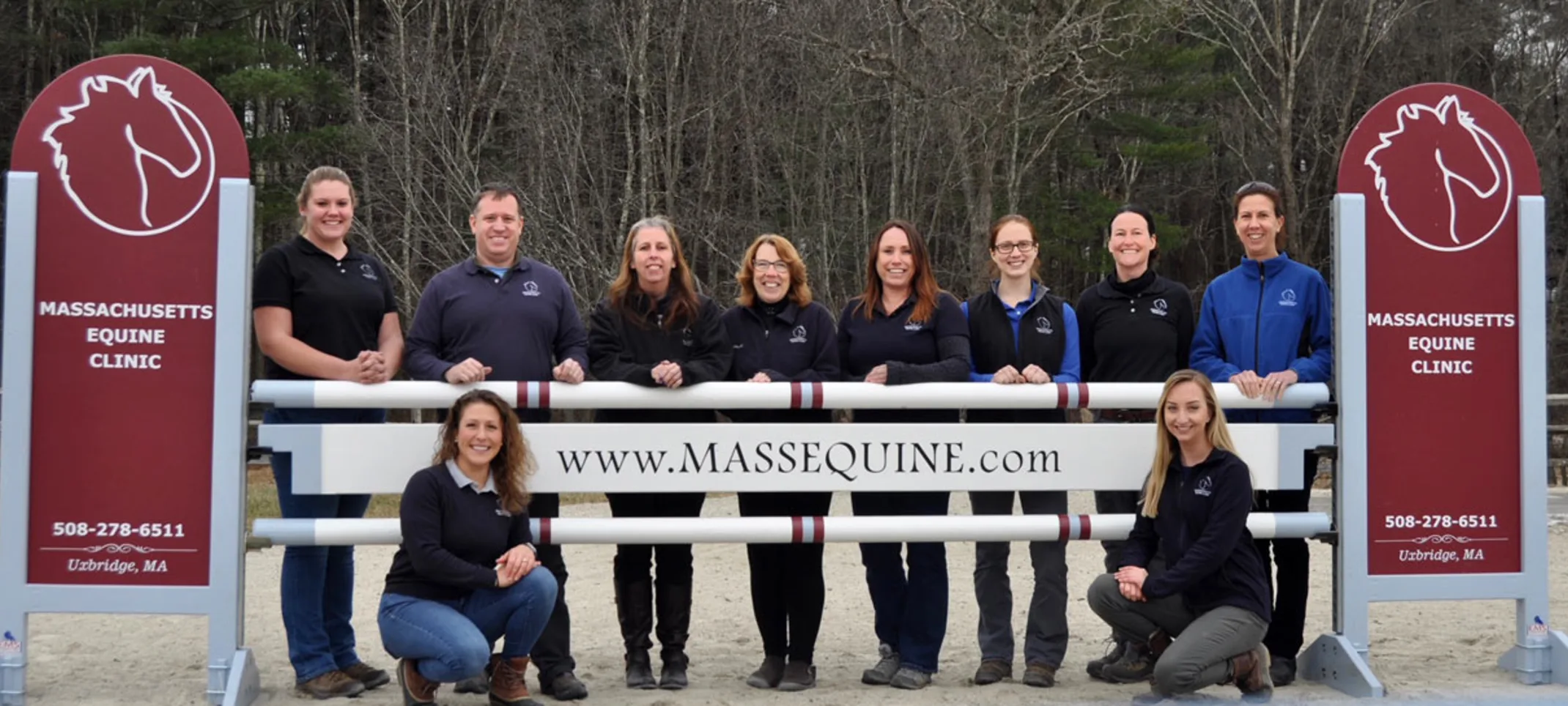 Staff standing by Mass Equine sign